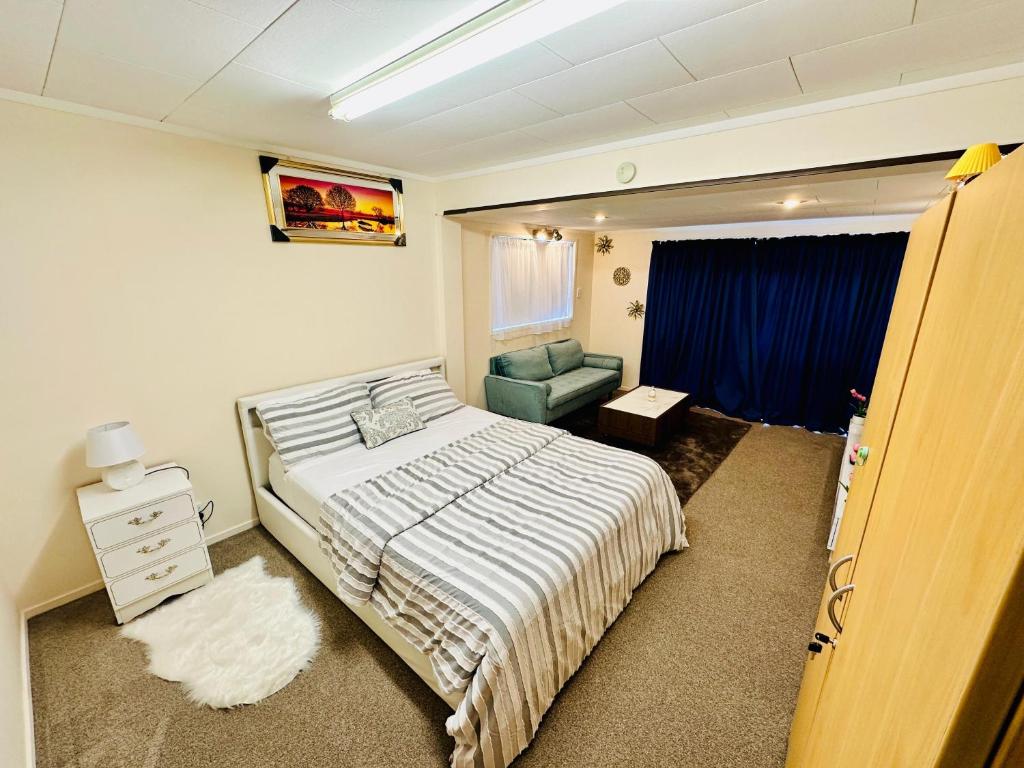 a bedroom with a bed and a chair in it at 2 Bedroom Homestay Close to Airport in Auckland