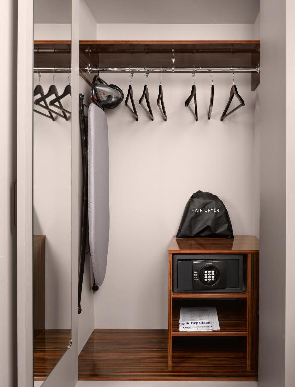 a walk in closet with a clock and shoes at Strand Palace in London
