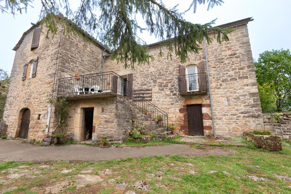 - un vieux bâtiment en pierre avec un chien sur un balcon dans l'établissement Gite de canilhac, à Canilhac