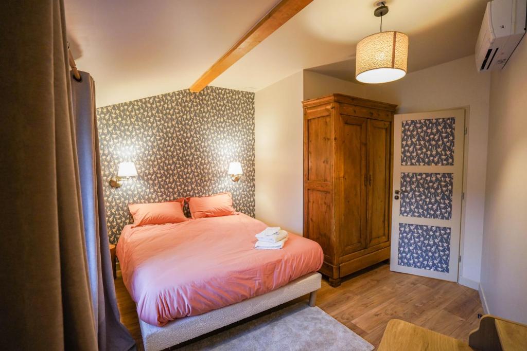 une petite chambre avec un lit et une porte en bois dans l'établissement Le Petit Paradis de Pruzilly, à Pruzilly