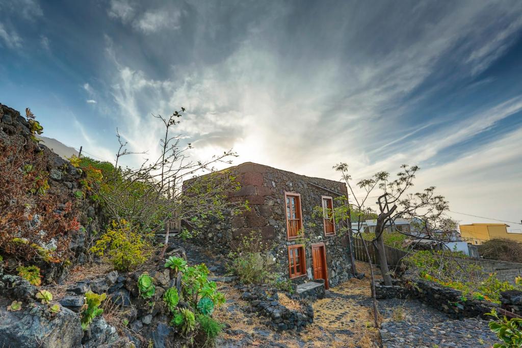 フロンテーラにあるCasa Rural De Piedraの天空の日が降り注ぐ丘の上のレンガ造りの家