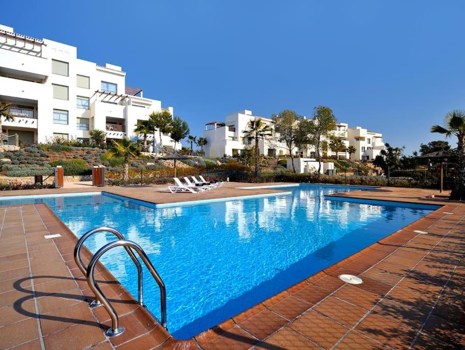 a large swimming pool in front of a building at Las Colinas Golf Club Residences Casa Encina 1 in Orihuela Costa