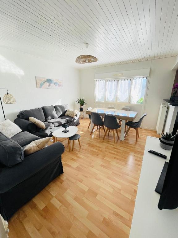 un salon avec un canapé et une table dans l'établissement Maison de Ville 3 Chambres avec Jardinet et Garage, à Grenade-sur-lʼAdour