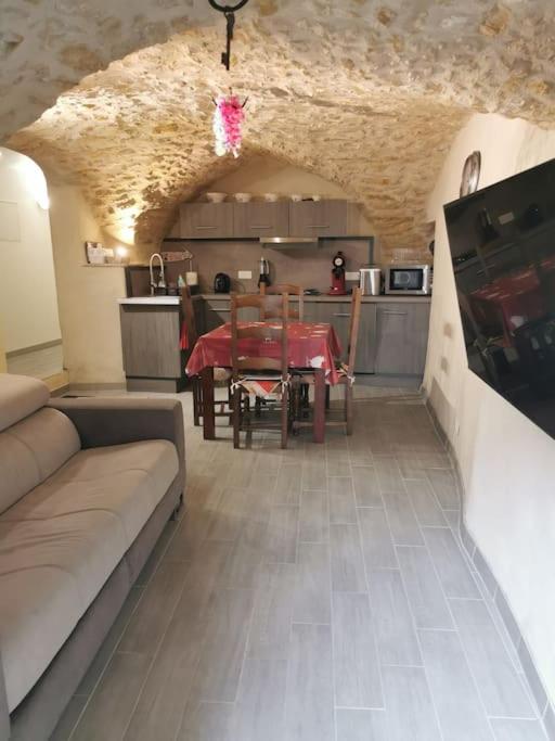 un salon avec un canapé et une table dans l'établissement Petite maison de village charmante et authentique, à Aniane