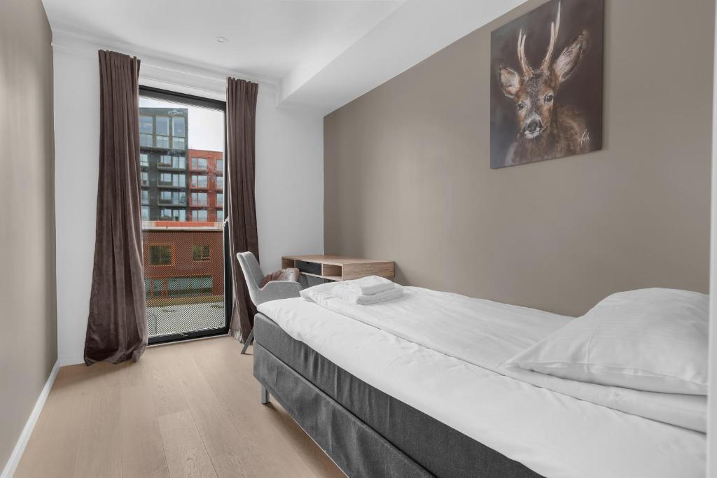 een slaapkamer met een bed met een foto van een hert aan de muur bij Northstay - The Northview Retreat, Free Parking, Amazing Ocean Views in Tromsø