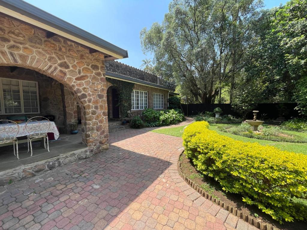 a brick house with a patio and an archway at Lavender Cottage in Hillcrest