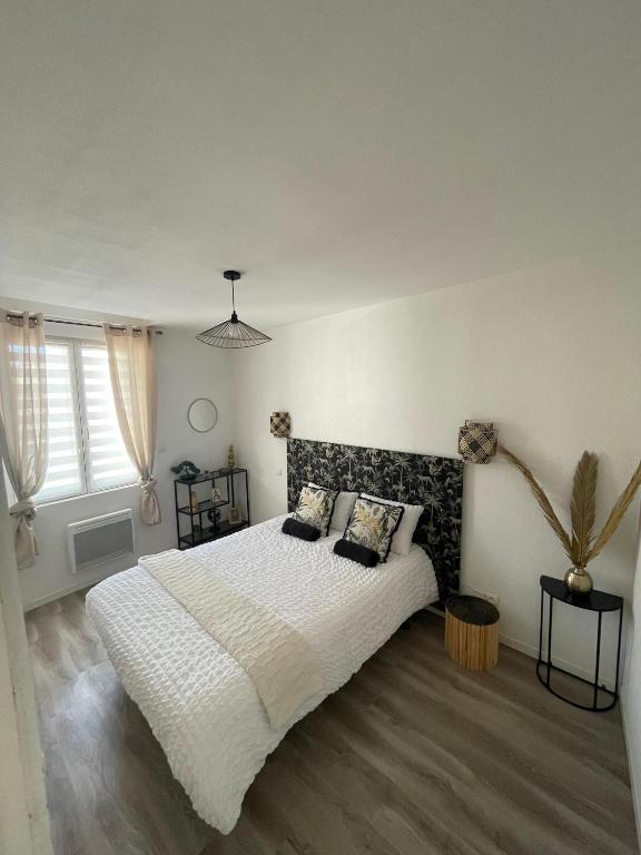 une chambre avec un grand lit blanc avec des oreillers dans l'établissement T4 Lumineux proche Centre Ville Narbonne & Des Grands Buffets, à Narbonne