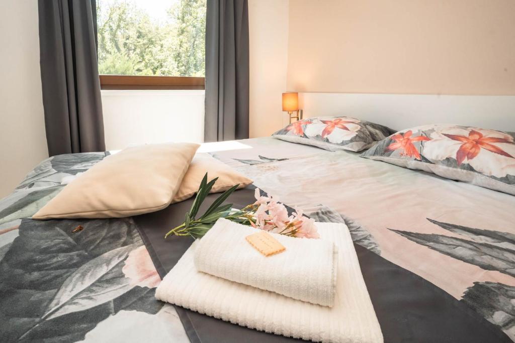 a bed with two towels on top of it at VSG Resort - Relaxing Apartments, 200m from the Sea, with Pool, Sauna & Jacuzzi in Klimno