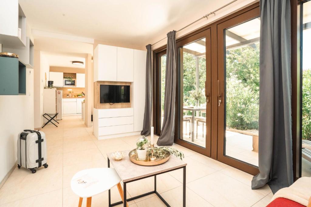 a living room with a table and a tv at VSG Resort - Relaxing Apartments, 200m from the Sea, with Pool, Sauna & Jacuzzi in Klimno