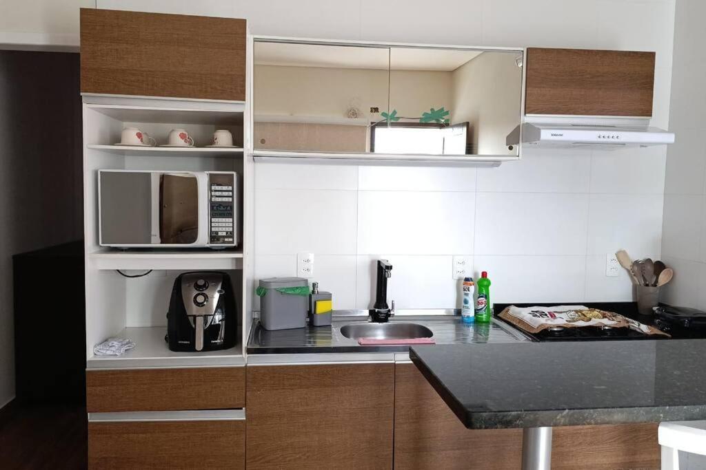 a kitchen with a sink and a microwave at Residencial Luce Del Sole - Apto N º 1 in Joinville
