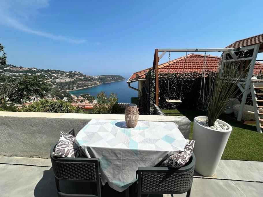 une table et des chaises avec vue sur l'eau dans l'établissement Studio vue mer dans villa moderne, à Roquebrune-Cap-Martin