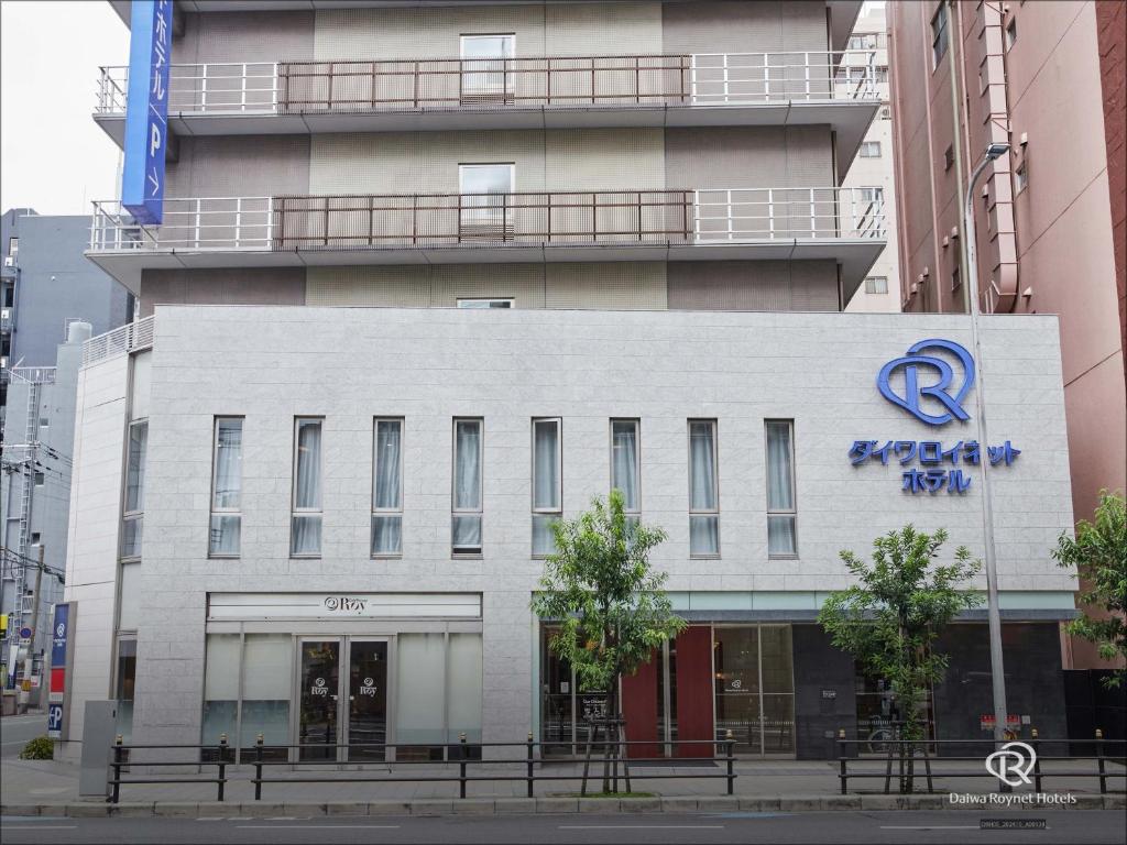 Un edificio con un cartel al costado. en Daiwa Roynet Hotel Osaka-Uehonmachi, en Osaka