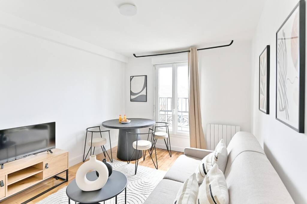 un salon blanc avec un canapé et une table dans l'établissement Appartement spacieux Proche de la capitale - II, à Montreuil