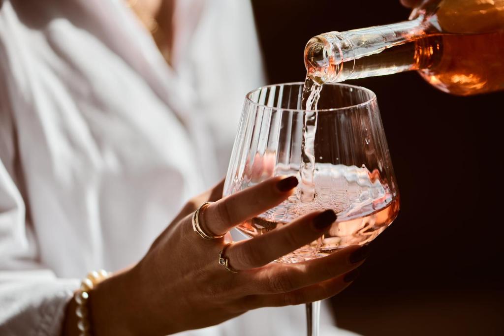 a woman pouring wine into a wine glass at The Saul in Tel Aviv