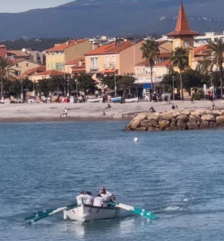 un homme dans un bateau dans l'eau près d'une plage dans l'établissement Cros de Cagnes Pins Sud Évasion, à Cros-de-Cagnes