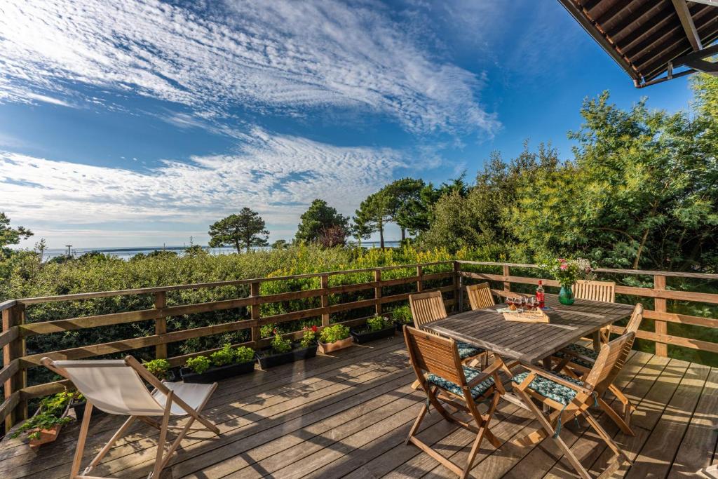 une terrasse en bois avec une table et des chaises dessus dans l'établissement Villa Diomedea - Welkeys, à La Teste-de-Buch