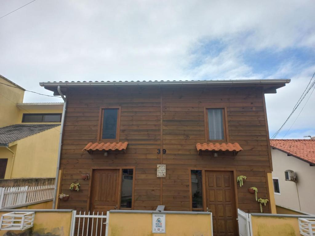 a wooden house with the front of it at Pousada Belas Praias Lofts da Riba in Imbituba
