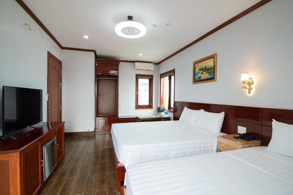 Postel nebo postele na pokoji v ubytování Minh Quang Hotel