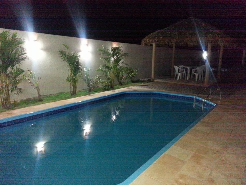 uma piscina à noite com luzes acesas em Pousada Brisa Do Pontal em Fortim