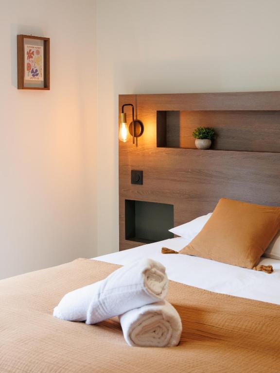 une chambre d'hôtel avec un lit avec une serviette dessus dans l'établissement Appart'hôtel Le Corot - Accès Autonome - Saint-Junien Centre, à Saint-Junien