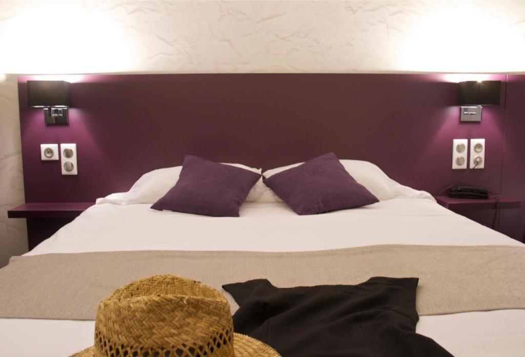 ロリアンにあるBRIT HOTEL LORIENT Le Kerotelの紫の壁のベッドルーム1室(大型ベッド1台付)