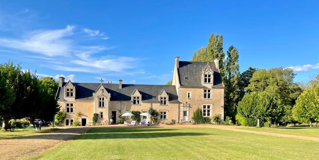une grande maison avec une grande pelouse dans l'établissement Château La Chevalerie - 24h du Mans, à Parigné-le-Pôlin