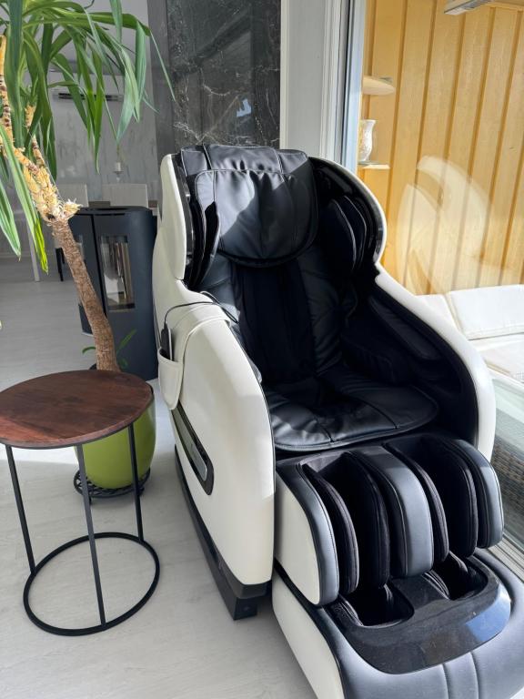 a black and white chair next to a table at Just Like Home Bed & Spa Porsgrunn in Porsgrunn