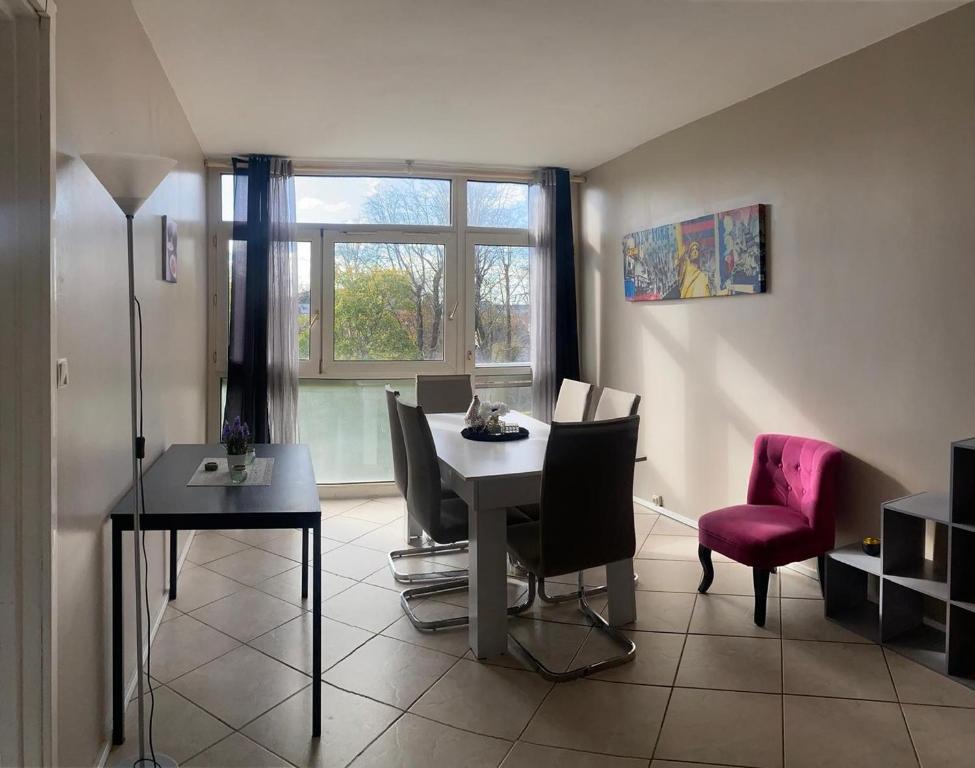 un salon avec une table et des chaises et une fenêtre dans l'établissement Évry : Grand Appartement 90m² pour 7 personnes, Évry-Courcouronnes