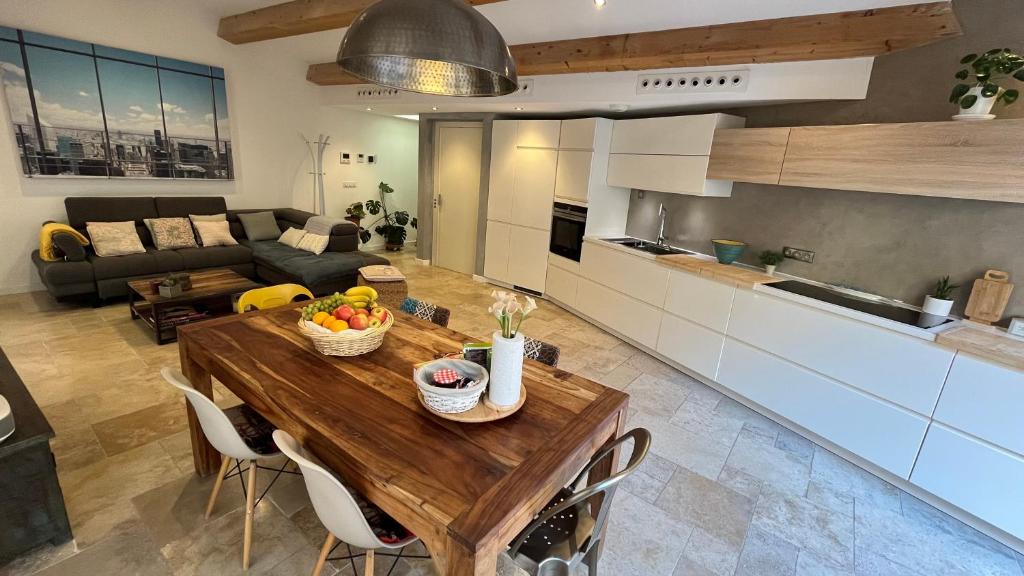 Il dispose d'une cuisine et d'un salon avec une table en bois et des fruits. dans l'établissement Residence Sao Jorge, à Cannes