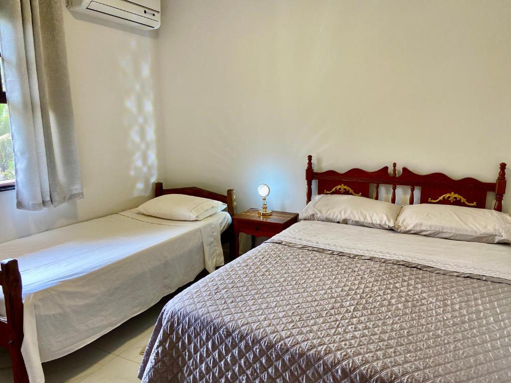 Giường trong phòng chung tại Casa Conforto Jacuzzi 2km do Centro Histórico