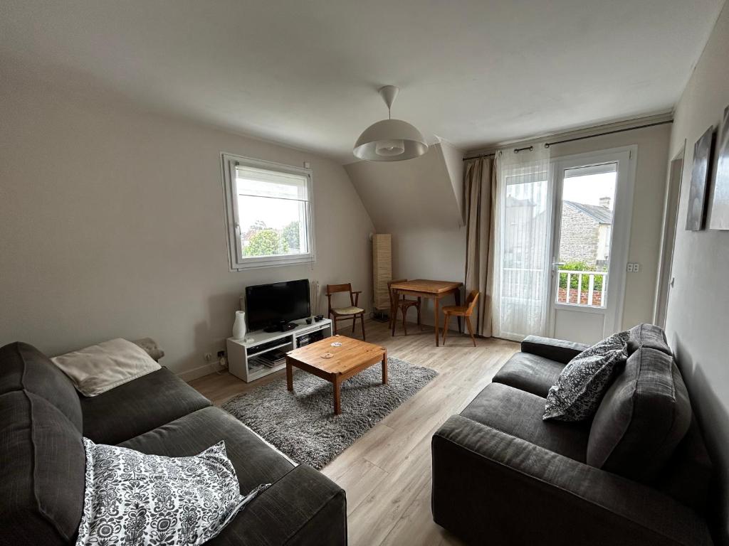 a living room with a couch and a table at Rayon De Soleil in Courseulles-sur-Mer