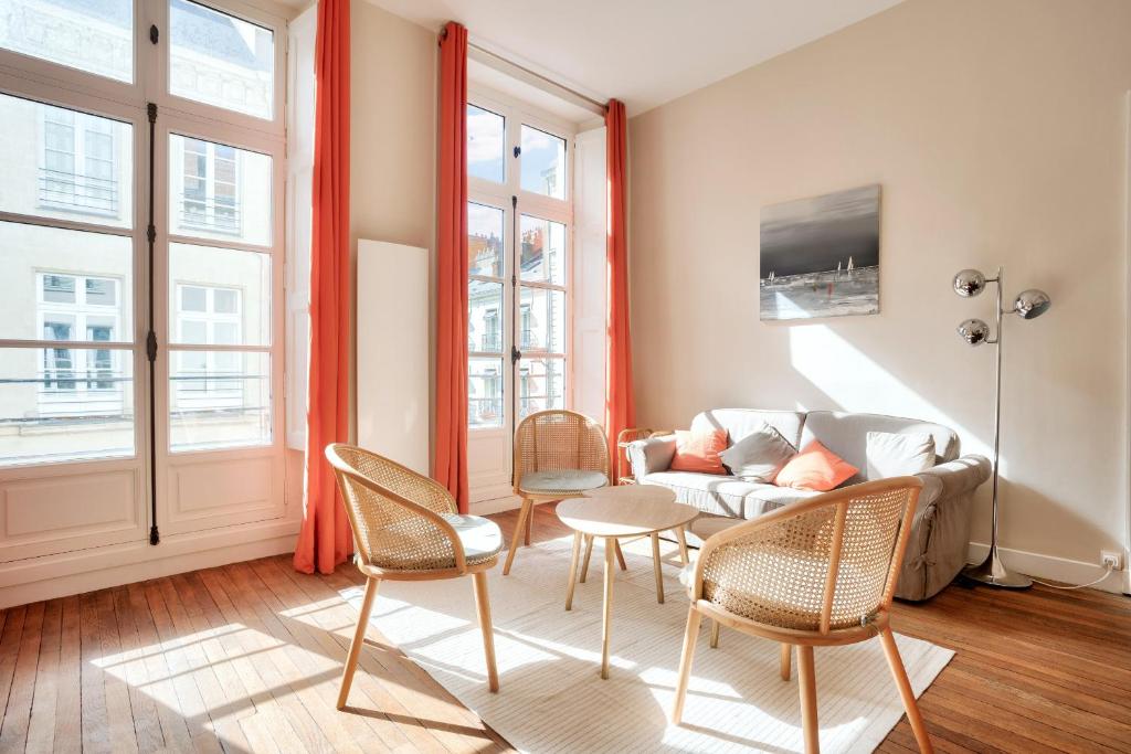 un salon avec un canapé, des chaises et des fenêtres dans l'établissement Au coeur du quartier Graslin, appartement pour 3, à Nantes