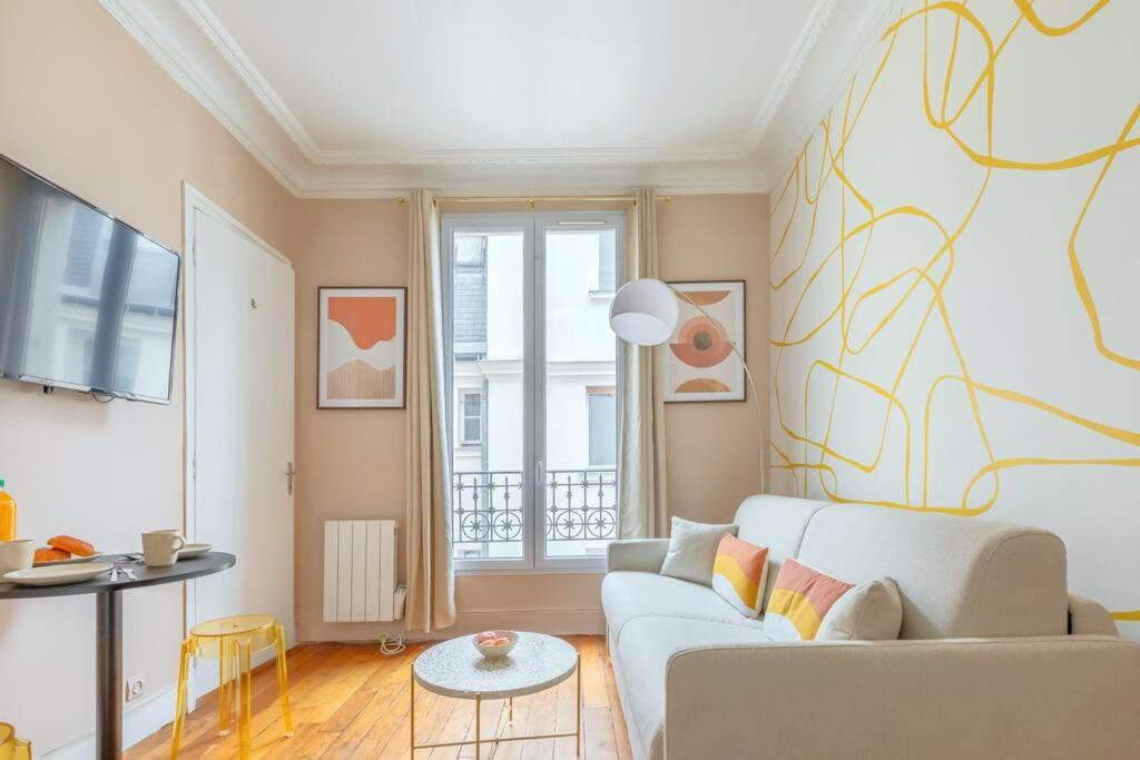- un salon avec un canapé blanc et une fenêtre dans l'établissement Joli 2 pièces dans un agréable quartier de Paris, à Paris