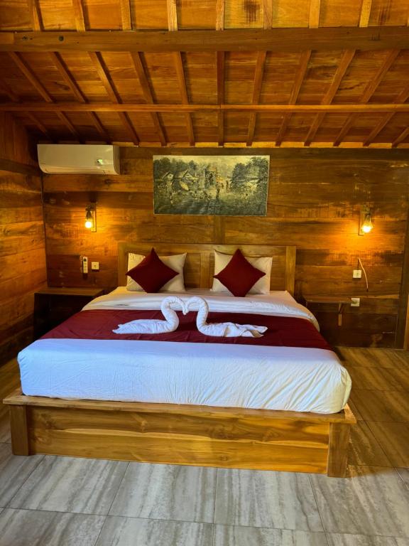 a bedroom with a large bed with wooden walls at Oemah Kangin Homestay in Amed