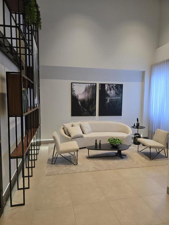 a living room with a couch and two chairs at Apto studio, coracao de maringa in Maringá
