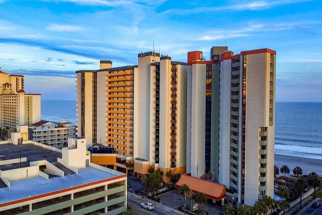 ein großes Gebäude mit dem Meer im Hintergrund in der Unterkunft Captivating Coastal Charm - Oceanview Suite! PG 504 in Myrtle Beach