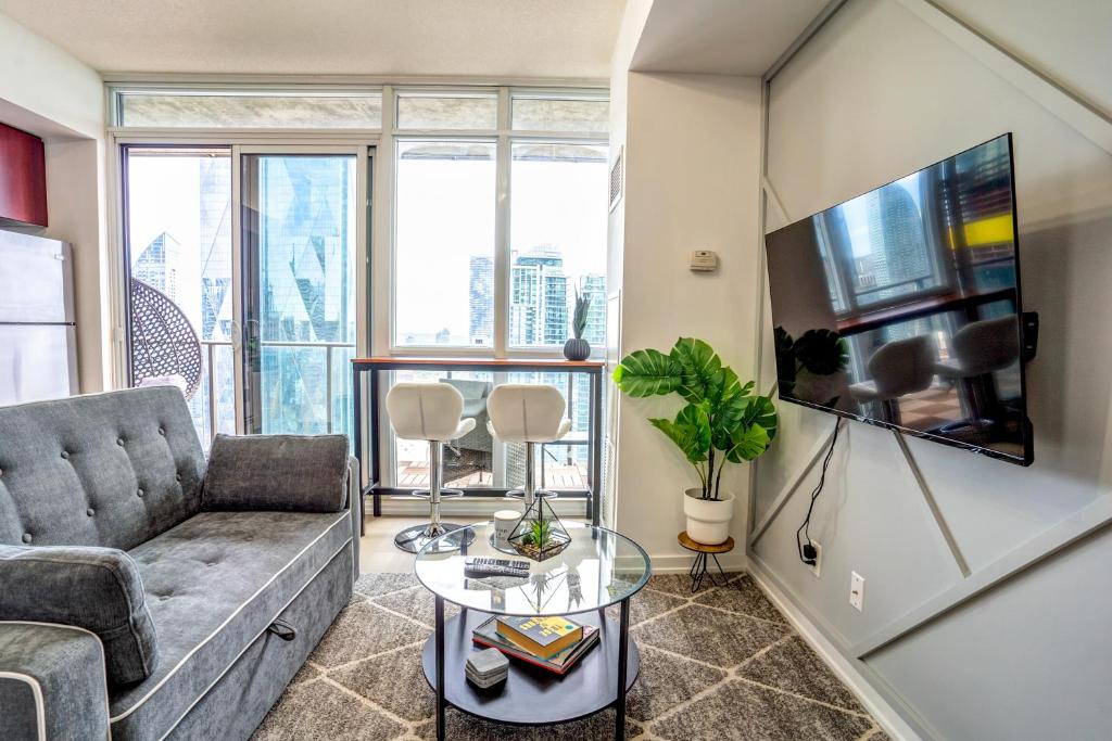un salon avec un canapé et une télévision dans l'établissement Luxury Condo Living Downtown Toronto, à Toronto