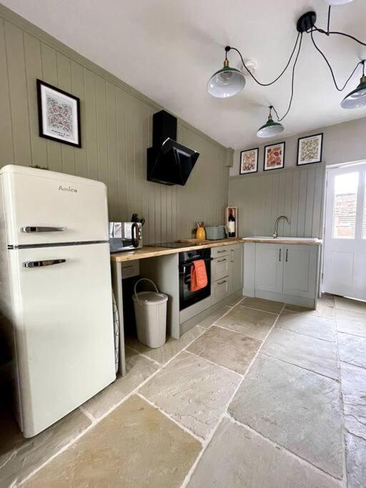 a kitchen with a white refrigerator in a room at TudorRose Townhouse - A New Unique Town Centre Home in King's Lynn