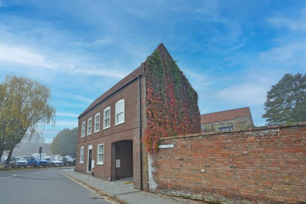 un bâtiment en brique avec du lierre sur son côté dans l'établissement TudorRose Townhouse - A New Unique Town Centre Home, à King's Lynn