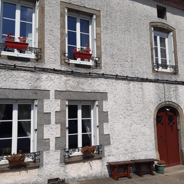 un bâtiment avec des fenêtres et un banc devant lui dans l'établissement Number 22 - Le Dorat - Apartment One with garden & free parking, au Dorat