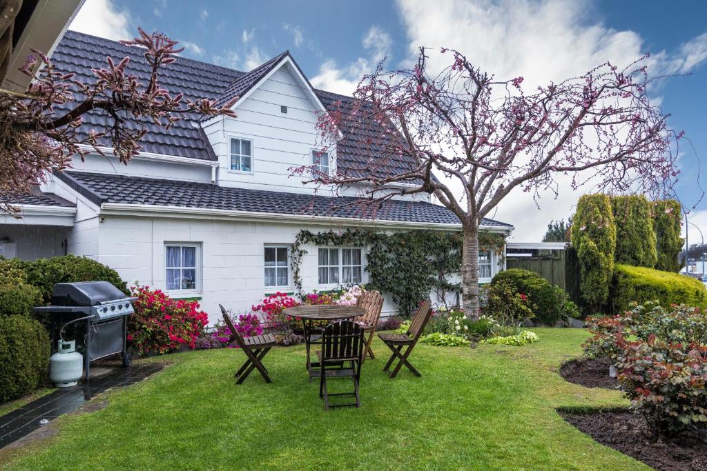 a yard with a table and chairs in front of a house at Phoenix Thermal Resort - Taupo in Taupo