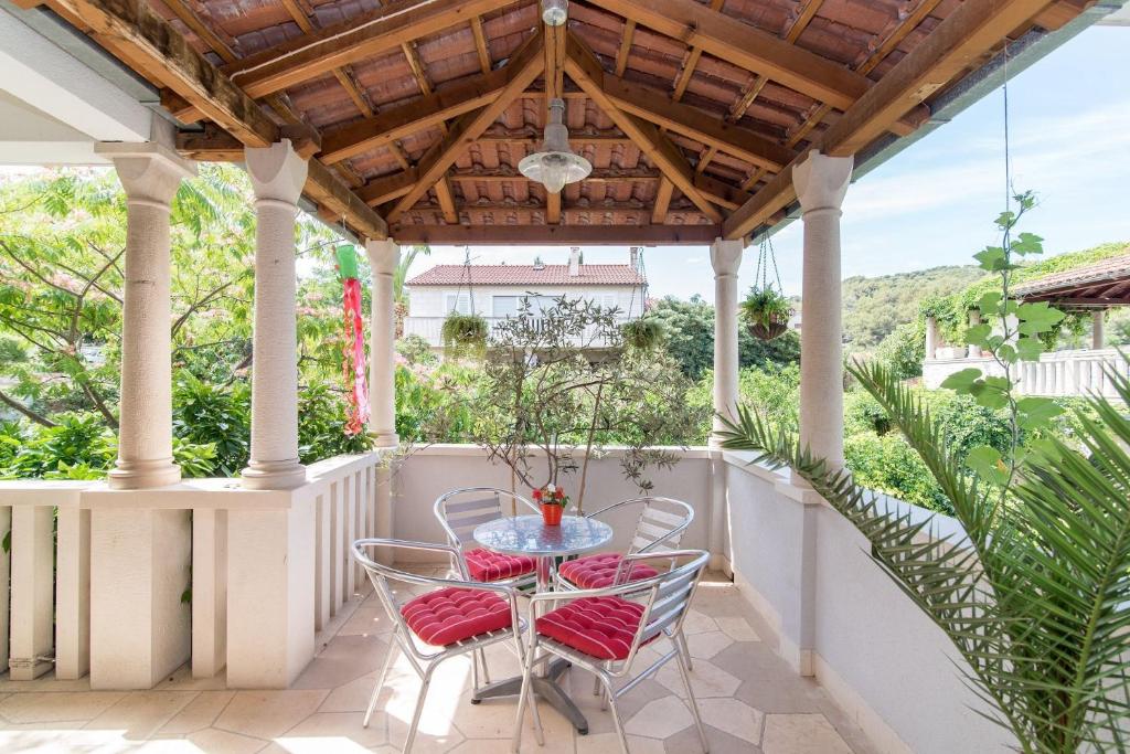 a patio with a table and chairs and a wooden ceiling at Apartment Damir in Postira