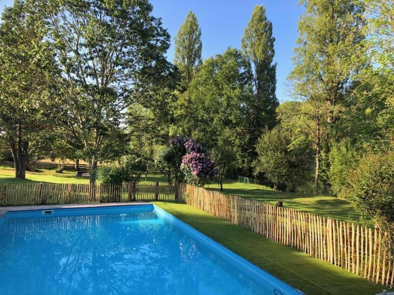 une piscine dans une cour clôturée dans l'établissement Le Cottage limousin, gîte de charme en bord de Vienne, à Saint-Brice-sur-Vienne