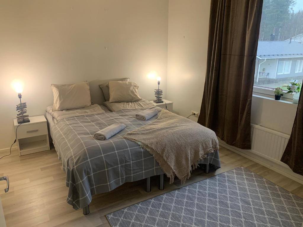 a bedroom with a bed with two pillows on it at Tuohilinna Apartment 2 in Rovaniemi