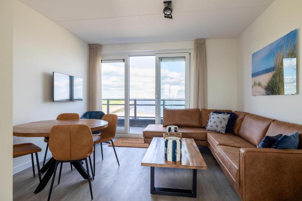 a living room with a couch and a table at Vakantiewoning aan het water - met 2 balkons - Vista Maris - Nr 52 in Sint Annaland