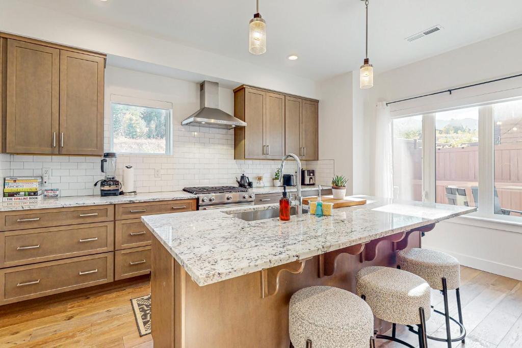 una cocina con armarios de madera y una gran isla con taburetes. en Sandlewood Sanctuary, en Park City