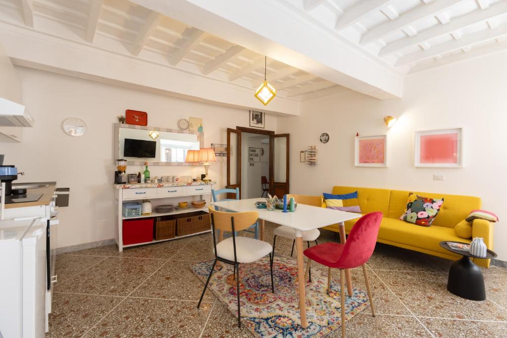 ein Wohnzimmer mit einem gelben Sofa und einem Tisch in der Unterkunft Perduta a Rome in Rom