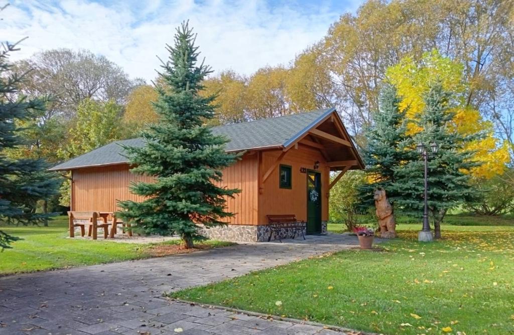 a cabin in a park with a pine tree at Tatralandia Chatka SnoWiki in Liptovský Mikuláš