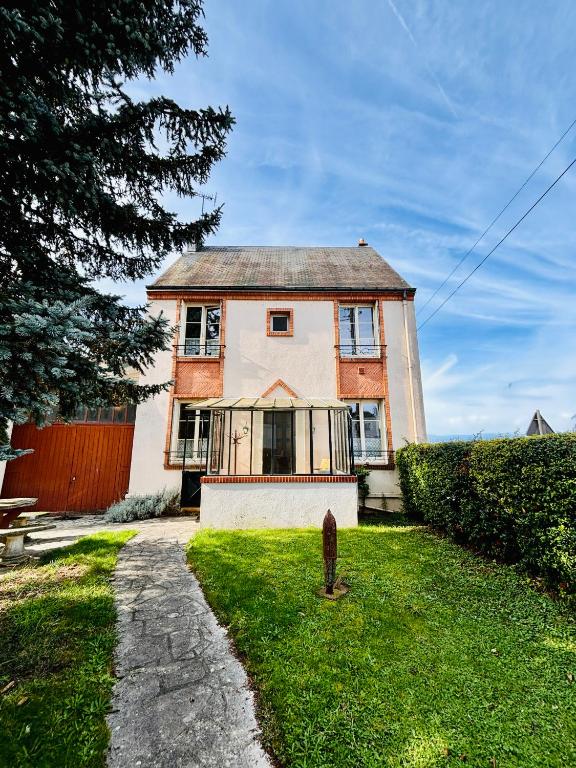 une vieille maison en briques avec un portail dans la cour dans l'établissement Le Repos du Marinier, à Gien
