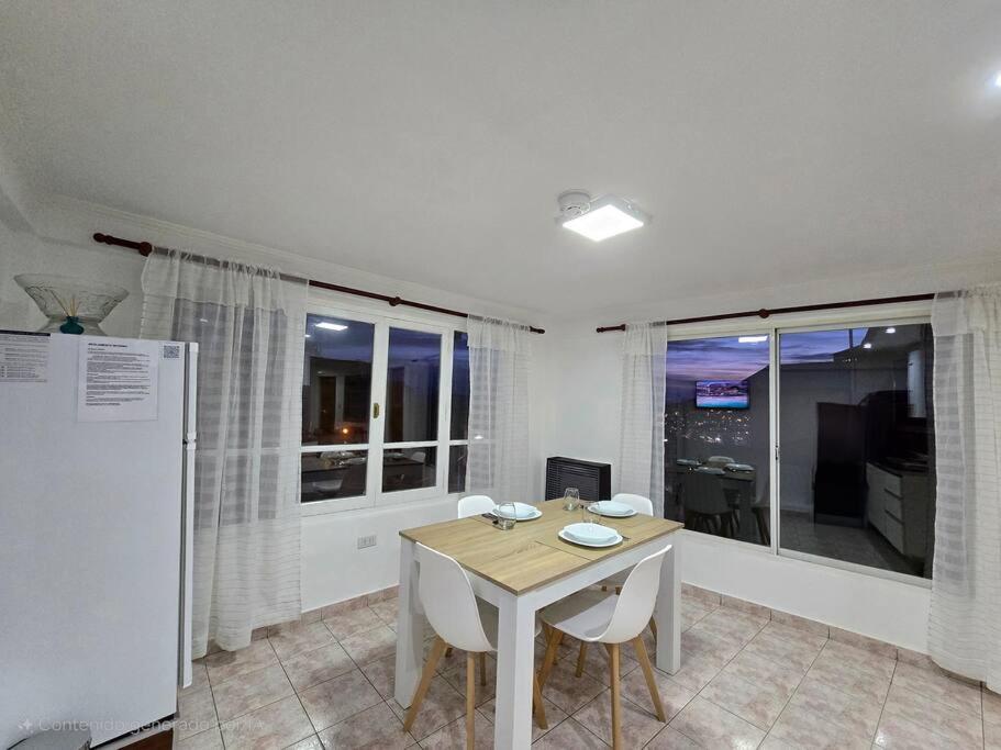 a dining room with a table and two chairs at Departamentos aćawaia in Ushuaia